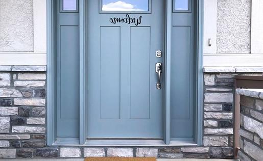 一扇蓝色的前门，上面铺着欢迎的垫子，上面写着“回家”。